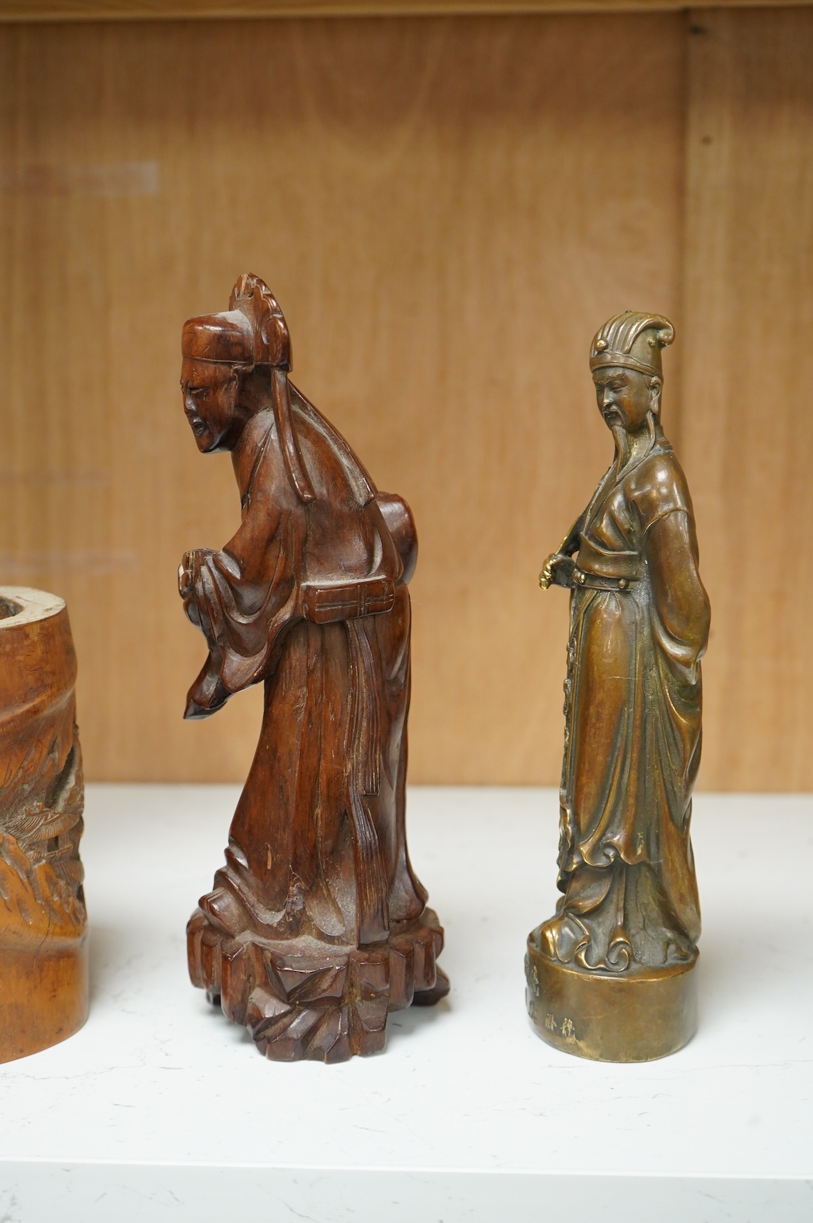 A bronzed Chinese figure of Qianlong, a carved bamboo brush pot and a hardwood figure, largest 20cm high